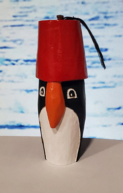 hand carved penguin wearing a fez